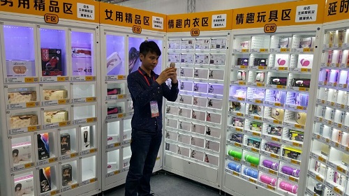 这家名为“嘿漫成人24小时无人售货店“的醒目的店名，店里摆着自助售货机，里面摆着各种成人用品，部分包装上显眼的文字和露骨的图案。